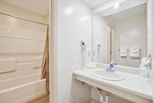 uma casa de banho branca com um lavatório e um chuveiro em Cedarbrook Queen Studio 110 em Killington