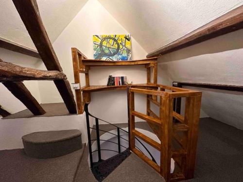 a attic room with a ladder and a book shelf at The Signature 1360’s - Modern Apartment in Barnet