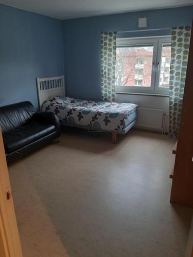 ein Wohnzimmer mit einem Sofa, einem Bett und einem Fenster in der Unterkunft Quiet room in Stockholm
