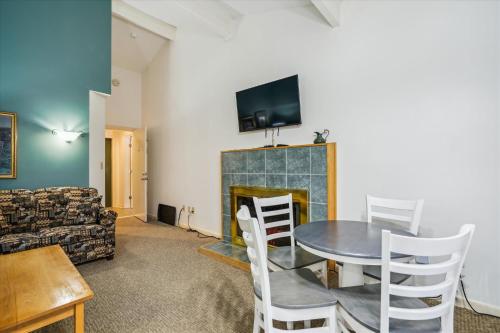 a living room with a table and a fireplace at Cedarbrook Deluxe Two Bedroom Suite with outdoor heated pool 20708 in Killington