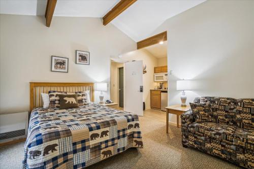 1 dormitorio con 1 cama y 1 silla en Cedarbrook Deluxe Two Bedroom Suite with outdoor heated pool 20708 en Killington