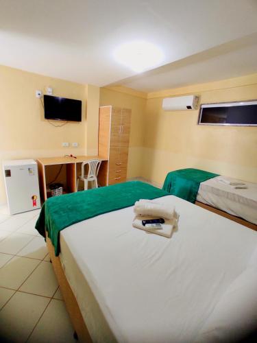 a hotel room with two beds and a desk at Amazônia Praia Hotel in Tibau