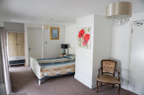 um quarto com uma cama, uma cadeira e um lustre em The Landmark em Cork