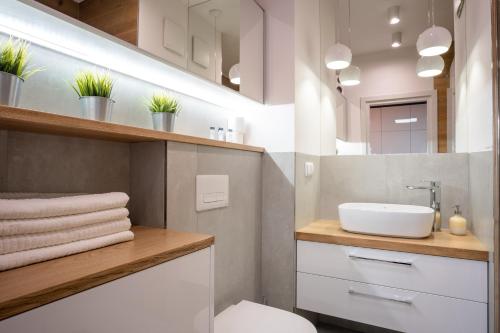 uma casa de banho com um lavatório, um WC e um espelho. em Kasprzaka 31A by Perfect Apart em Varsóvia