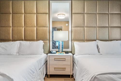 a hotel room with two beds and a mirror at 3 Palms Tucson North Foothills in Tucson