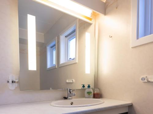 a bathroom with a sink and a large mirror at Aurora Dream House Apartment with free parking in Tromsø