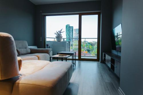 ein Wohnzimmer mit einem Sofa und einem großen Fenster in der Unterkunft The Heart of Tirana in Tirana