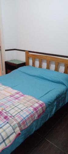 ein Bett mit einer blauen Decke darüber in der Unterkunft 8C Departamento con Vista al Mar in Mar del Plata