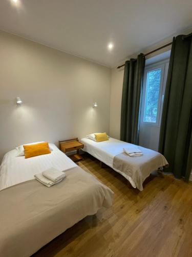 a bedroom with two beds and a window with curtains at Quartos privados - Quinta da Paz in Santa Cruz