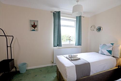 um quarto com uma cama e uma janela com cortinas azuis em Comfy Quarters from 'TOBS Norwich' em Norwich