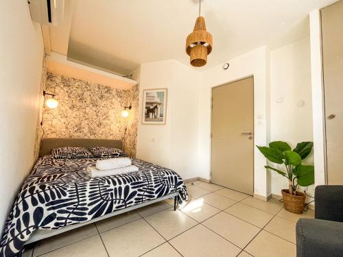 a bedroom with a bed and a potted plant at Suite Cumba in Villeurbanne