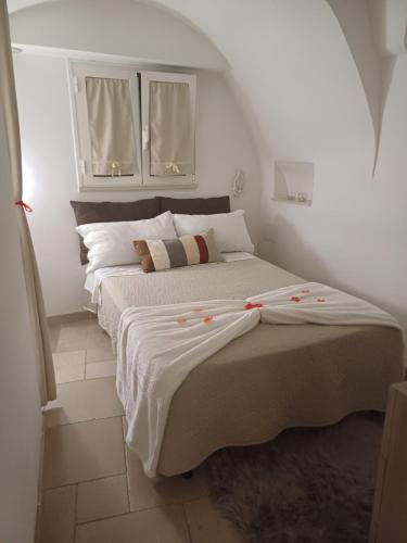 a bedroom with a large bed with two windows at Suite 800 in Ostuni