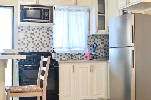 uma cozinha com um frigorífico de aço inoxidável e um micro-ondas em Tamra’s Getaway em Montego Bay
