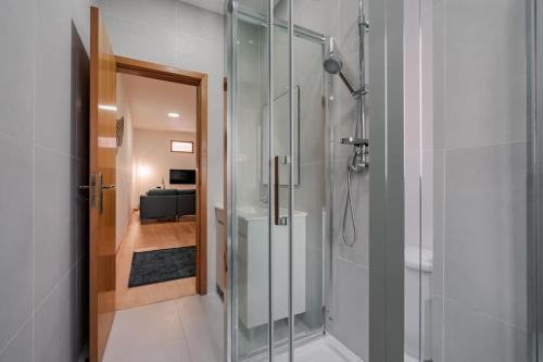 a bathroom with a shower with a glass door at Modern studio near Metro Station in Senhora da Hora