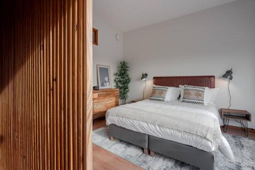 a bedroom with a large bed and a wooden closet at Modern studio near Metro Station in Senhora da Hora