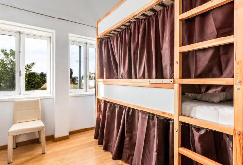 um quarto com um beliche e duas janelas em C&f hostel em Porto