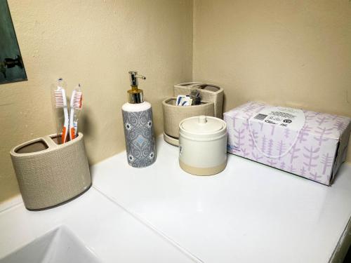 a bathroom counter with toothbrushes and a box on it at Tamra’s Getaway in Montego Bay