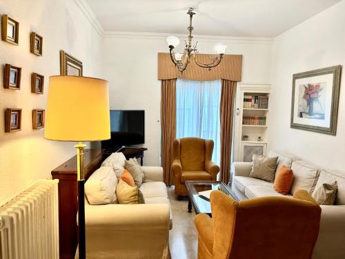 una sala de estar con 2 sofás y una lámpara. en Piso en calle Recogidas (Centro), en Granada