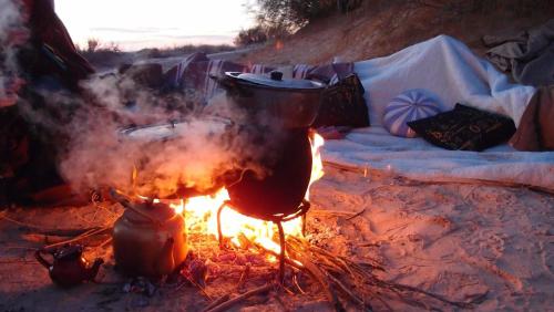 a fire with a pot on top of it at Maison Proche De Désert Douz in Douz