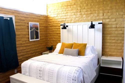 una camera da letto con un letto bianco con cuscini gialli di The Three Keys duplex a Sedona