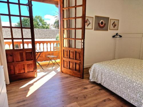een slaapkamer met een deur naar een balkon bij Jacaranda Azul Icod de los Vinos in Icod de los Vinos