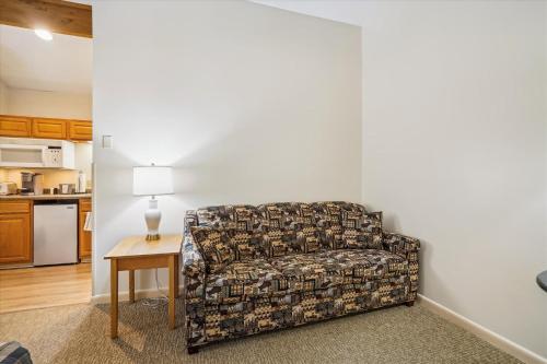 a living room with a couch and a table at Cedarbrook Queen Studio 207 in Killington
