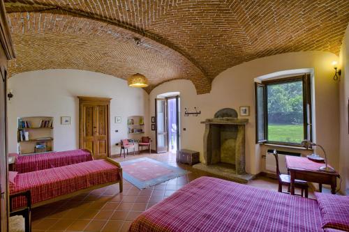 a living room with red couches and a fireplace at B&B Cascina Moncrava in Ivrea