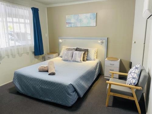 um quarto com uma cama e uma cadeira em Hatton Vale Motel em Hatton Vale