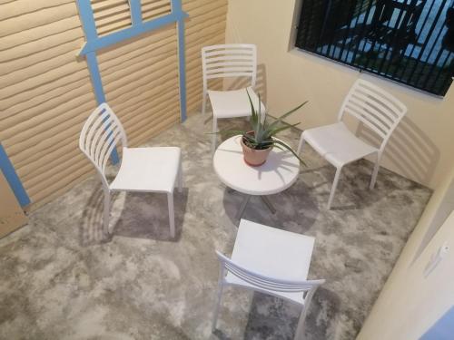 a group of white chairs and a table and a plant at El Conde de Villa Rosa in Salado