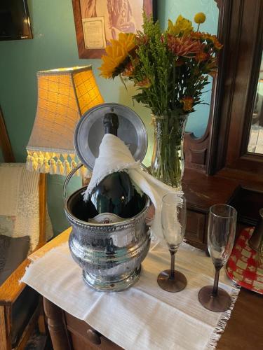 a bottle of wine in a bucket on a table with two glasses at Downtown B&B with Jacuzzi in Glenwood Springs