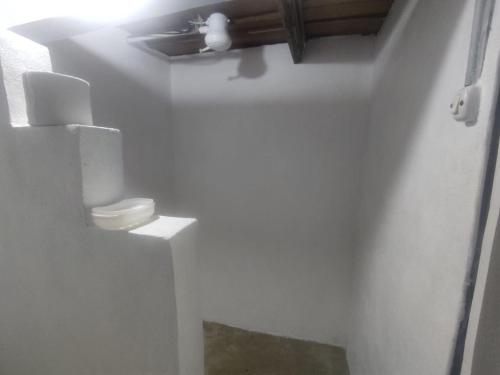 a white bathroom with a toilet in a room at Pequeño paraíso Río Celeste in San Rafael