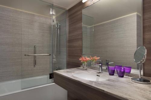 a bathroom with a sink and a shower with purple glasses at Lake Biwa Marriott Hotel in Moriyama