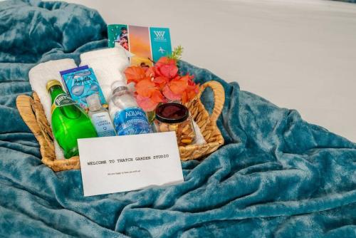 a basket of toiletries and a sign on a blanket at Thatch Garden Apartment in Long Bay Village