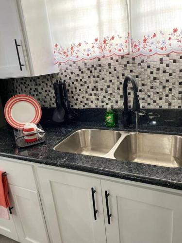 a kitchen counter with a sink and a window at Thatch Garden Apartment in Long Bay Village