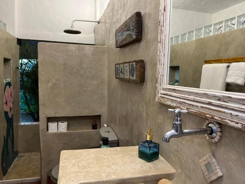 ein Bad mit einem Waschbecken, einem Spiegel und einer Dusche in der Unterkunft Oca House in Búzios