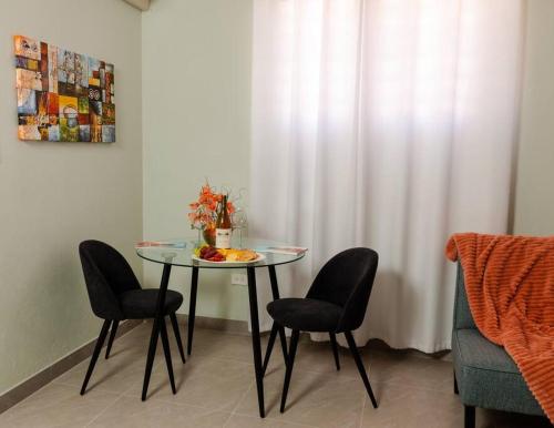 a table with chairs and a bowl of fruit on it at Thatch Garden Apartment in Long Bay Village