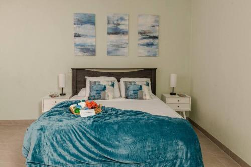 um quarto com uma cama com um cobertor azul em Thatch Garden Apartment em Long Bay Village