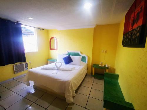 a bedroom with a bed in a yellow room at Casa Real in Poza Rica de Hidalgo