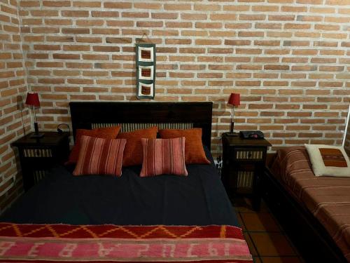 1 dormitorio con cama y pared de ladrillo en Pintoresca casa con pileta in 