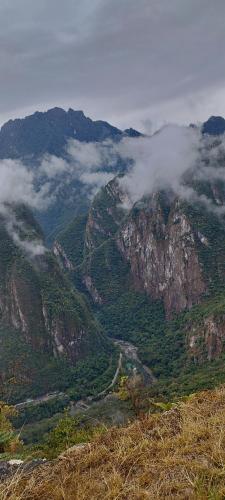 a view of a mountain with clouds on it at Amakonkay Machupicchu in Machu Picchu