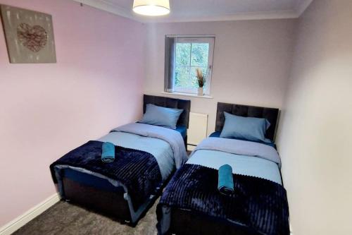 a bedroom with two beds with blue pillows at 9 Guest 7 Beds Lovely House in Rossendale in Newchurch
