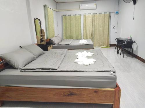 two beds sitting in a room with two at Sappermpool Homestay Buengkhonglong 