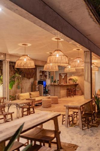 a large room with tables and chairs and chandeliers at Villa Mango Jeri in Jericoacoara