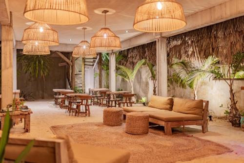 een lobby met een bank, tafels en kroonluchters bij Villa Mango Jeri in Jericoacoara