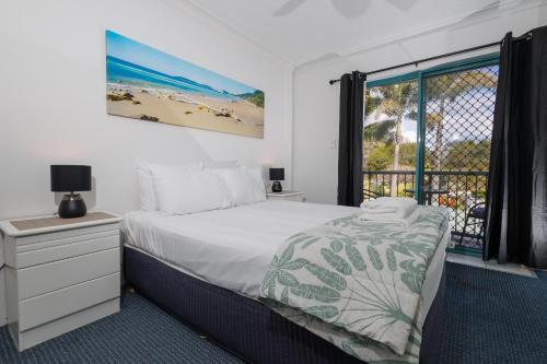 a bedroom with a bed and a view of a beach at Pacific Place Apartments in Gold Coast