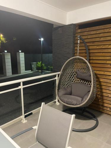 a hanging chair on a balcony with a laptop at Charmante maison avec jacuzzi in Le Gosier