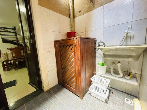 a bathroom with a sink and a wooden cabinet at Aluguel Apto. Triplex Guaramiranga. in Guaramiranga