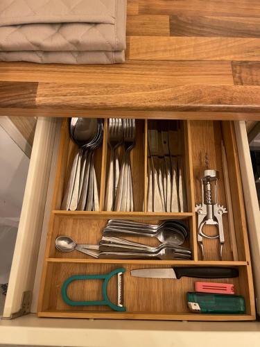 a drawer in a cabinet filled with utensils at AptStays in Cardiff