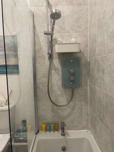 ein Bad mit einer Dusche und einem Waschbecken in der Unterkunft AptStays in Cardiff