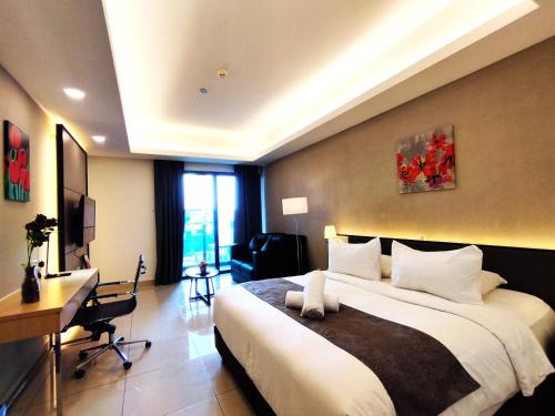 a bedroom with a large bed and a desk and a computer at TopGenting RosyColdSuite4Pax @GrdIonDelmn in Genting Highlands
